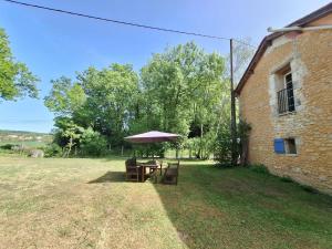 a table with an umbrella next to a building at The Lodge Gite 3 Star in Saint-Privat-des-Prés +5 photos