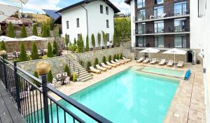 a swimming pool with chairs and a building at LOFT Hotel & SPA in Bukovel +69 photos