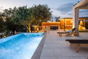 a swimming pool with benches next to a house at Kallisti Luxury Villa in Kallithea Rhodes +56 photos