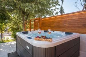 a hot tub with wine glasses and a basket of fruit at Kallisti Luxury Villa in Kallithea Rhodes