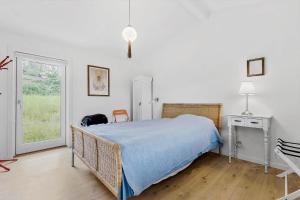 a bedroom with a bed with a blue blanket at 84159-Ebeltoft-Koravej-5 in Ebeltoft