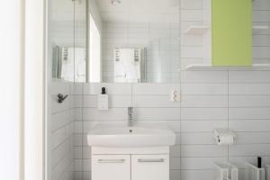a white bathroom with a sink and a mirror at Sky Hotel Apartments Tornet in Linköping