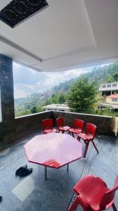 a group of red chairs and a table on a balcony at Luxury Apartment in Khaira Gali +6 photos