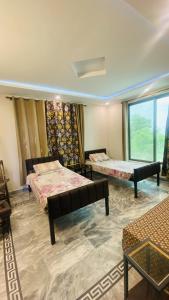a room with two beds and a window at Luxury Apartment in Khaira Gali