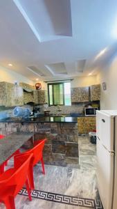 a kitchen with red chairs and a refrigerator at Luxury Apartment in Khaira Gali