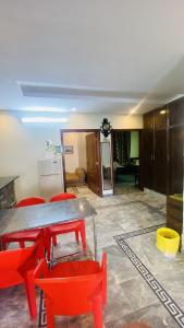 a living room with a table and red chairs at Luxury Apartment in Khaira Gali