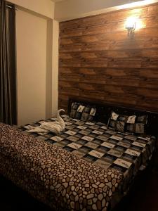 a bedroom with a bed with a swan on it at Pine & Peaks in Patta