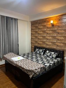 a bedroom with a bed with a wooden wall at Pine & Peaks in Patta