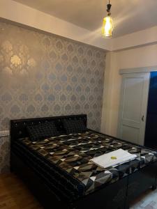 a bedroom with a bed with a checkerboard patterned wall at Pine & Peaks in Patta