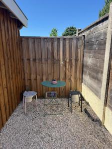 a patio with a table and two chairs and a fence at Studio Bruges centre-ville in Bruges