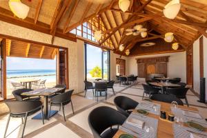 a restaurant with tables and chairs and the beach at Ananea Madivaru Maldives in Toroka