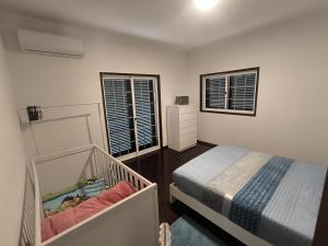 a bedroom with a bed and a crib in it at Centro da cidade Amarante 168 in Amarante