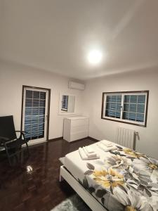 a white bedroom with a bed and two windows at Centro da cidade Amarante 168 in Amarante +5 photos