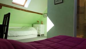 a white bedroom with two beds and a window at La Rivetière in Courcemont