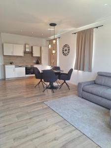 a living room with a blue couch and a table at Murtal Appartement Größingblick Top 1 in Zeltweg