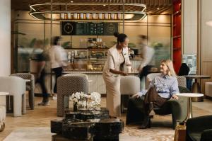 two women sitting in chairs in a room with a table at Pullman Dubai Jumeirah Lakes Towers in Dubai +68 photos