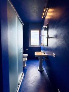a blue bathroom with a sink and a toilet at Nuvola 24 - Casa Vacanza in Rimini