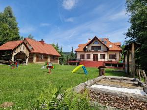 a yard with playground equipment in front of a house at Gościniec Pięciu Stawów in Ustrzyki Dolne +144 photos