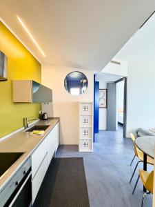 a kitchen with yellow and blue walls and a table at Nuvola 24 - Casa Vacanza in Rimini +2 photos
