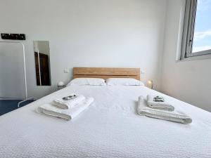 a bedroom with a white bed with towels on it at Nuvola 24 - Casa Vacanza in Rimini