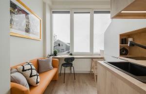 a living room with an orange couch in a kitchen at Cosy apartment in Vilnius +14 photos