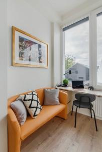 a living room with a couch and a desk with a laptop at Cosy apartment in Vilnius