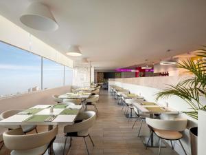 a dining room with white tables and chairs at ibis Styles Sharjah in Sharjah
