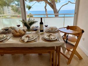a table with glasses of wine and food and a window at Apartamento con terraza y vistas al mar - Tree House Salou in Salou