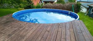 a pool on a wooden deck with a blue pool at Vila Pramínek, Krkonoše s bazénem kousek od Pece pod Sněžkou in Horní Maršov