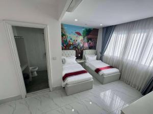 a bathroom with two beds and a painting on the wall at Center Point Resident in Phnom Penh