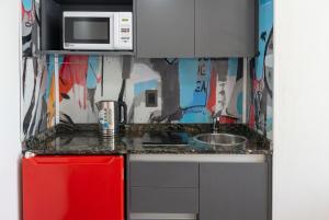 a small kitchen with a red refrigerator and a microwave at Estudio Lino in Córdoba