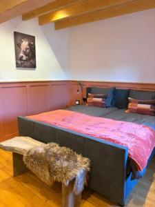 a bedroom with a large bed with a dog picture on the wall at Vue sur la colline La-Roche in Bouzais