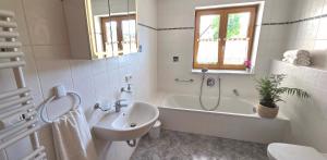 a bathroom with a tub and a sink and a toilet at Lake&Mountain Apartments in Andechs +18 photos