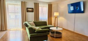 a living room with a green chair and a table at Lake&Mountain Apartments in Andechs
