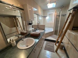 a bathroom with two sinks and a shower and a tub at Chez Amélie in Crémieu +6 photos