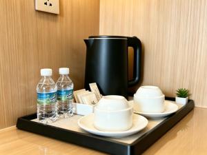 a tray with plates and bottles of water and a coffee pot at BTC Hotel 比特币酒店 in Malacca