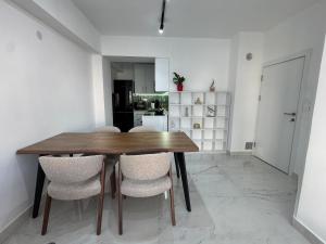 a dining room with a wooden table and chairs at Stylish Ohrid Apartment, Hot Tub, Steps to Lake in Ohrid