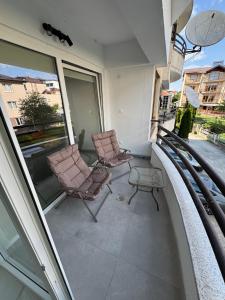 two chairs and a table on a balcony at Stylish Ohrid Apartment, Hot Tub, Steps to Lake in Ohrid
