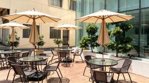 an outdoor patio with tables and chairs and umbrellas at BTC Hotel 比特币酒店 in Malacca
