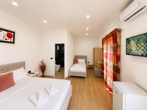 a bedroom with a white bed and a couch at PRIAM Beach Borsh in Borsh