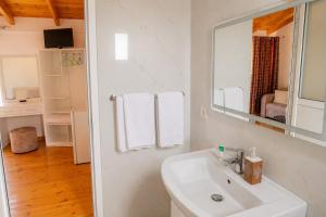 a white bathroom with a sink and a mirror at PRIAM Beach Borsh in Borsh +4 photos
