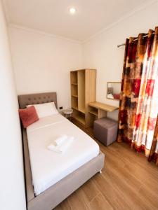 a bedroom with a bed and a desk in a room at PRIAM Beach Borsh in Borsh