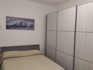 a bedroom with a bed and a large cabinet at Villaggio Sa Ventana in Badesi