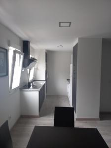 a kitchen with a sink and a table in a room at Casa de la Soledad 3 in Lugo