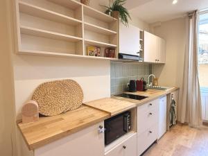 a kitchen with white cabinets and a counter top at Le Stervin in Villefranche-sur-Saône +6 photos