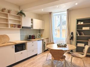 a kitchen with a table and chairs in a room at Le Stervin in Villefranche-sur-Saône