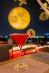 a red drink in a martini glass on a table at Suvarnabhumi Suite Hotel - Suvarnabhumi Airport, Bangkok in Lat Krabang