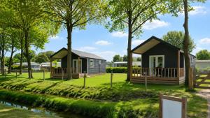 a cabin in a park next to a river at Camping ’t Veld in Rheeze