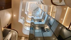 a glass staircase in a building with a window at The Olive Hotel Srinagar in Srinagar