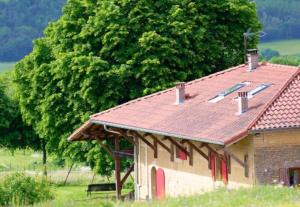 an old building with a red roof on a field at Domaine Mariedal in Hauterives